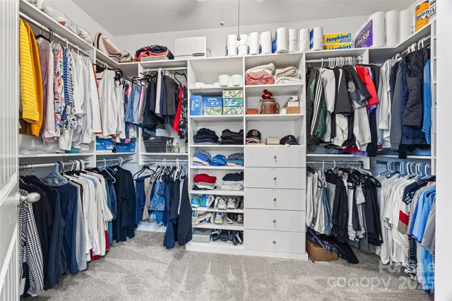 a view of walk in closet with clothes and shoes