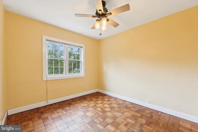 an empty room with a window and a fan