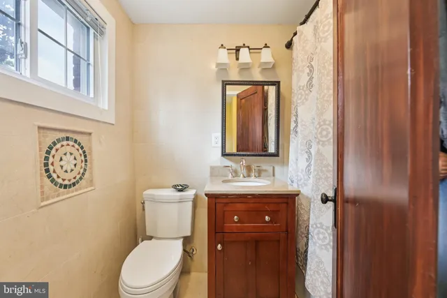 a bathroom with a toilet a sink and a mirror