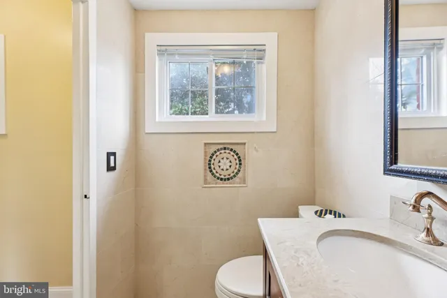 a bathroom with a granite countertop toilet sink and mirror