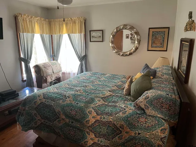 a bedroom with a bed mirror and a window