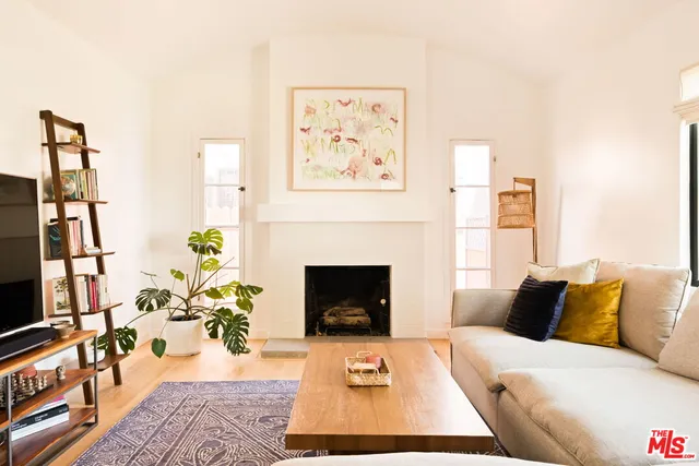 a living room with furniture a fireplace and a flat screen tv