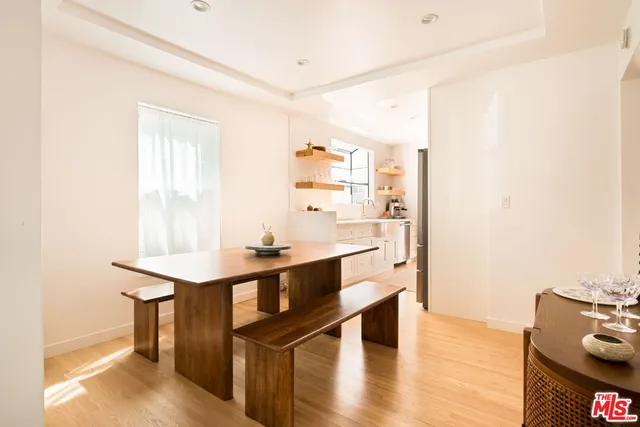 a view of a kitchen with kitchen island a sink wooden floor and living room view