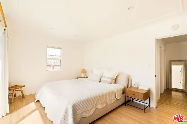a bedroom with a bed and wooden floor
