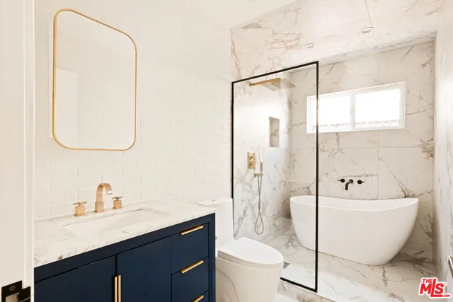 a bathroom with a white toilet sitting next to a bathroom sink and a shower