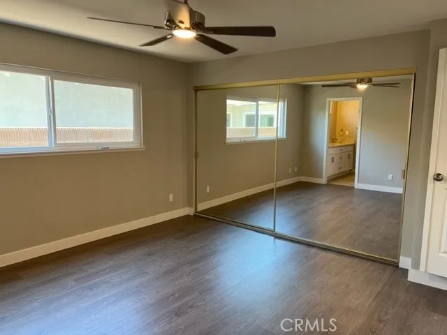 a view of a livingroom with wooden floor and a ceiling fan