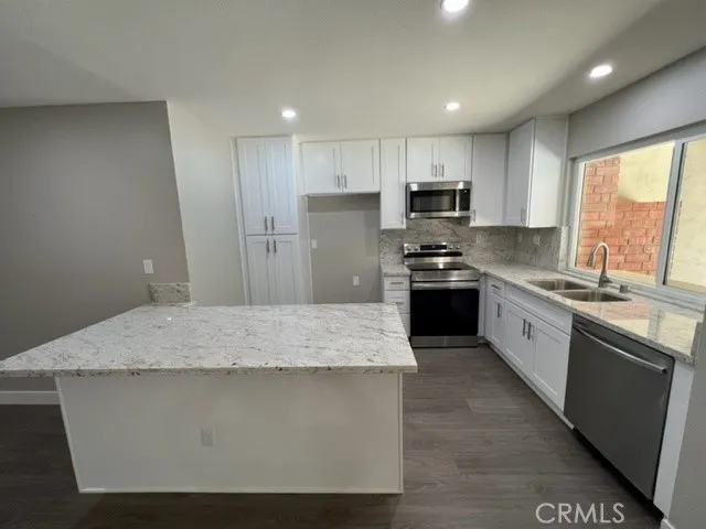a kitchen with granite countertop stainless steel appliances and wooden cabinets