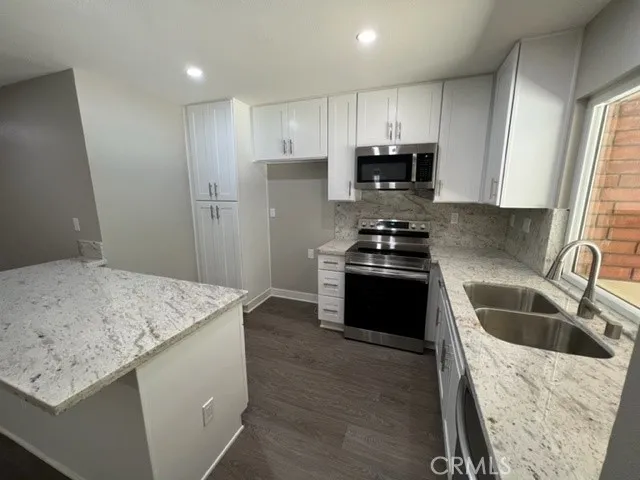 a kitchen with granite countertop a stove and a sink