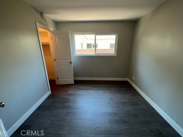 an empty room with wooden floor and a window