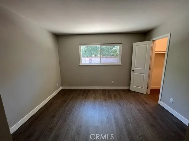 an empty room with wooden floor and entrance