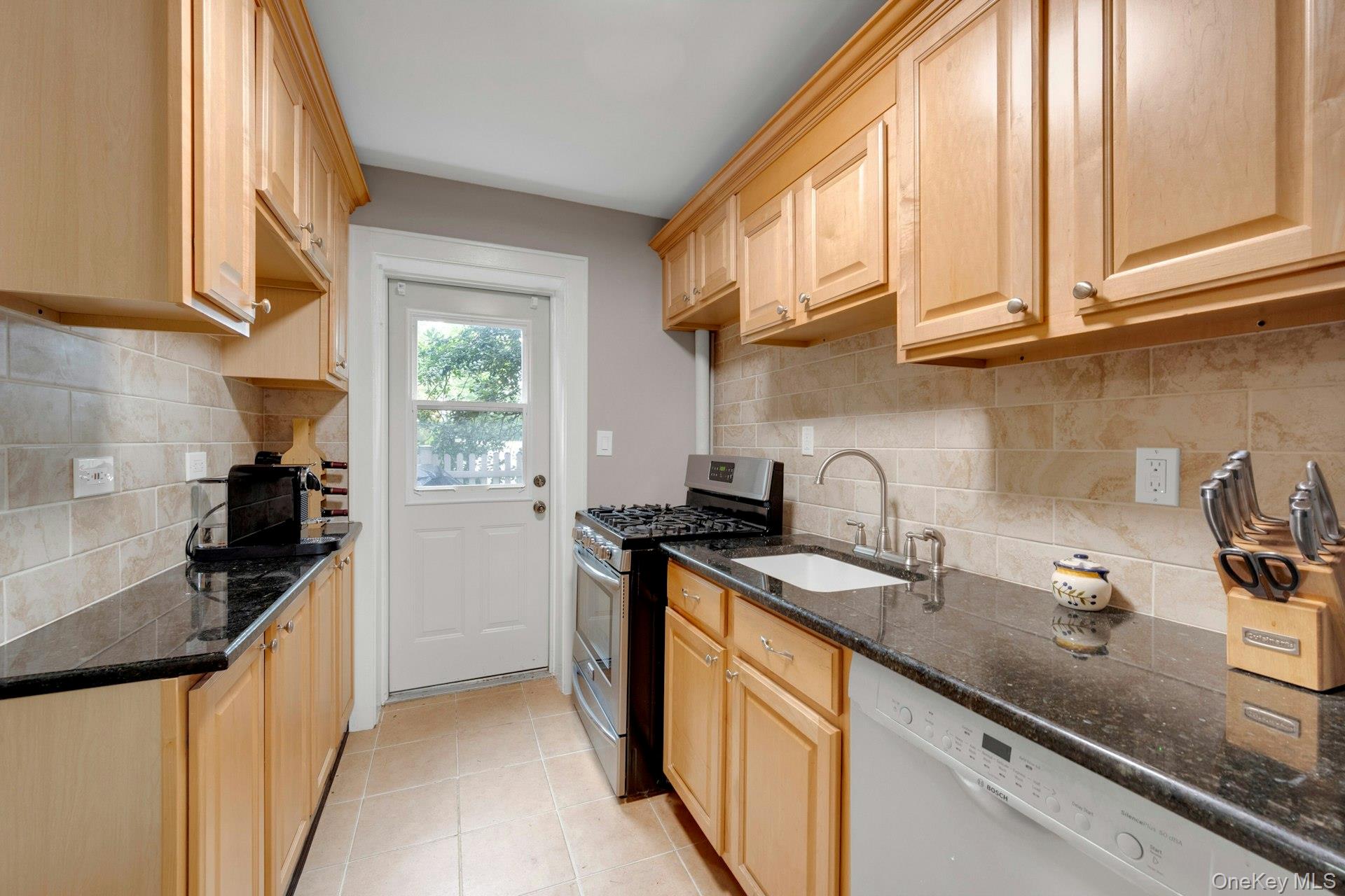 6 Manchester Road, Unit 1 Eastchester, NY 10709 - Photo 12 of 40 Kitchen featuring appliances with stainless steel finishes, dark stone countertops, and light brown cabinetry