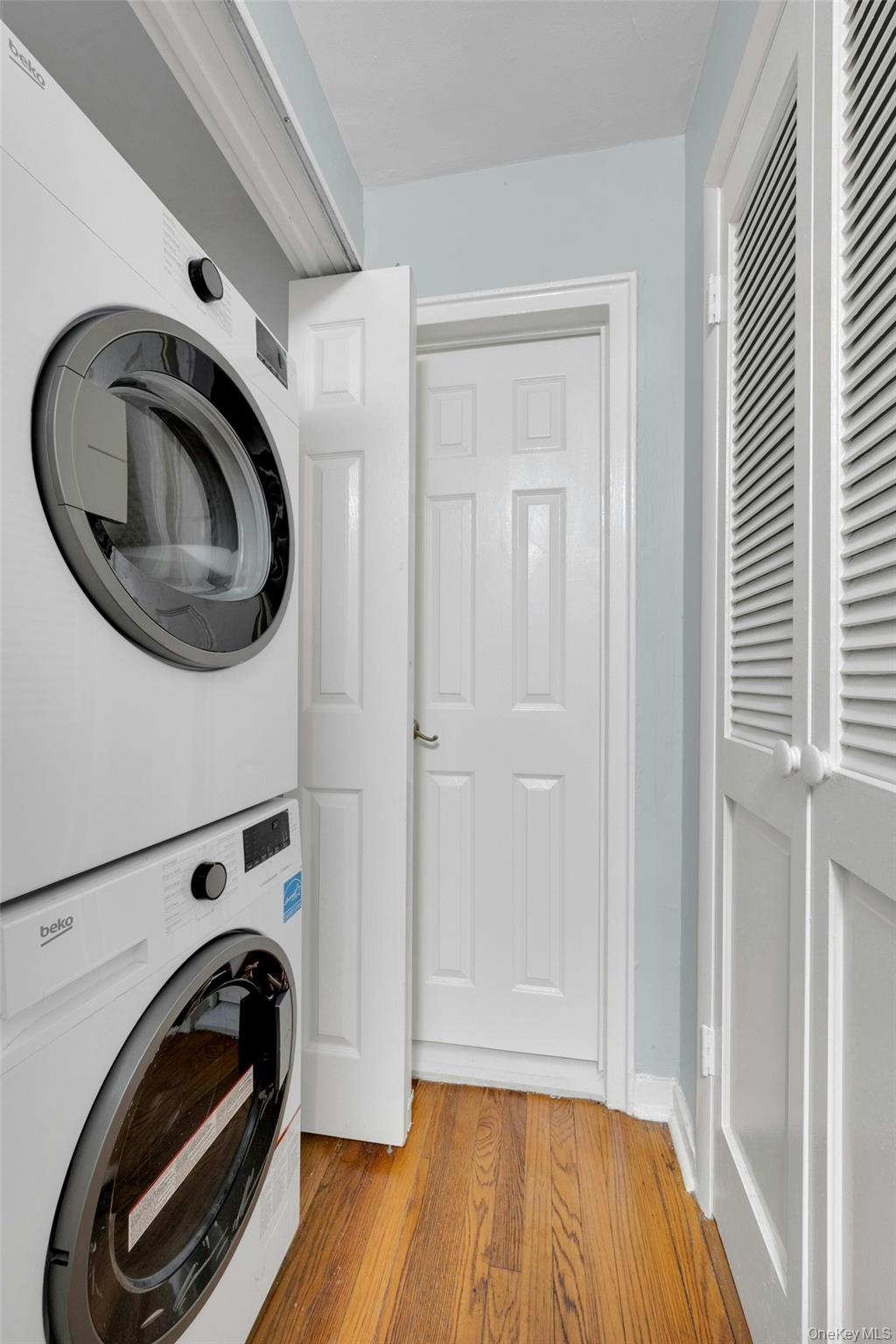 6 Manchester Road, Unit 1 Eastchester, NY 10709 - Photo 21 of 40 Laundry area with light wood-type flooring and stacked washer and clothes dryer