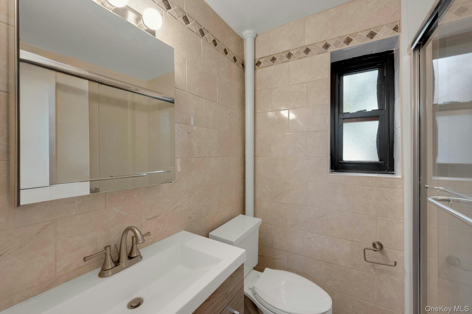 6 Manchester Road, Unit 1 Eastchester, NY 10709 - Photo 23 of 40 Bathroom featuring tile walls, vanity, a shower stall, and backsplash