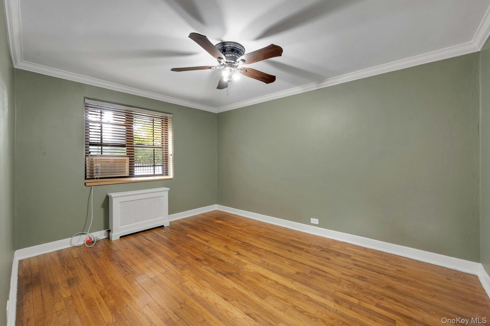 6 Manchester Road, Unit 1 Eastchester, NY 10709 - Photo 24 of 40 Spare room featuring ornamental molding, wood-type flooring, and a ceiling fan