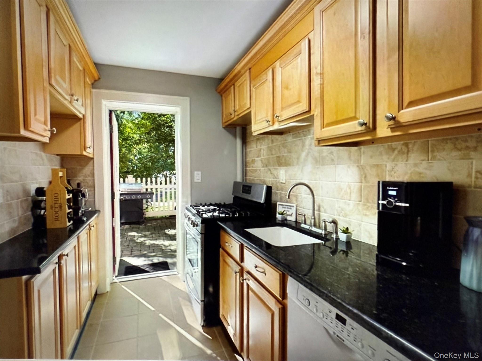 6 Manchester Road, Unit 1 Eastchester, NY 10709 - Photo 7 of 40 Kitchen with gas stove, dark stone countertops, dark tile patterned flooring, tasteful backsplash, and dishwasher