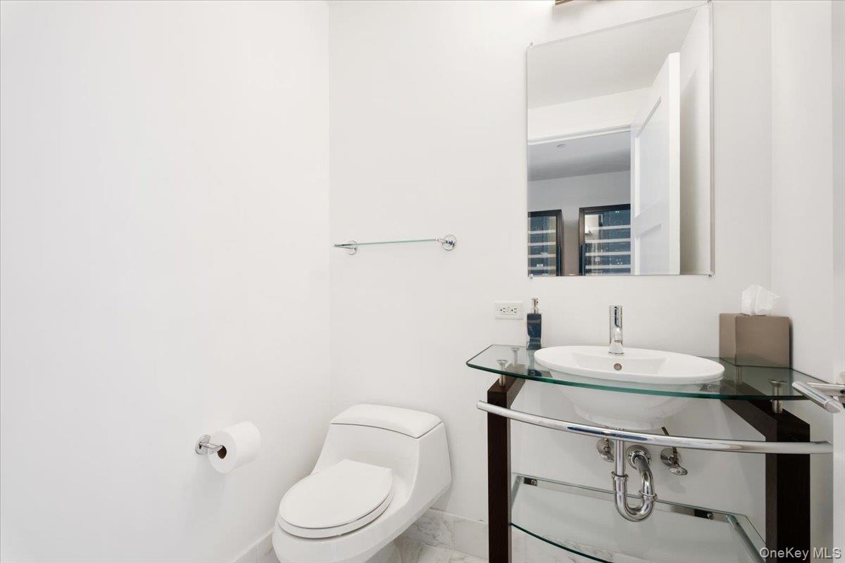 5 Renaissance Square, Unit PH 3E White Plains, NY 10601 - Photo 14 of 26 a bathroom with a toilet a sink and mirror