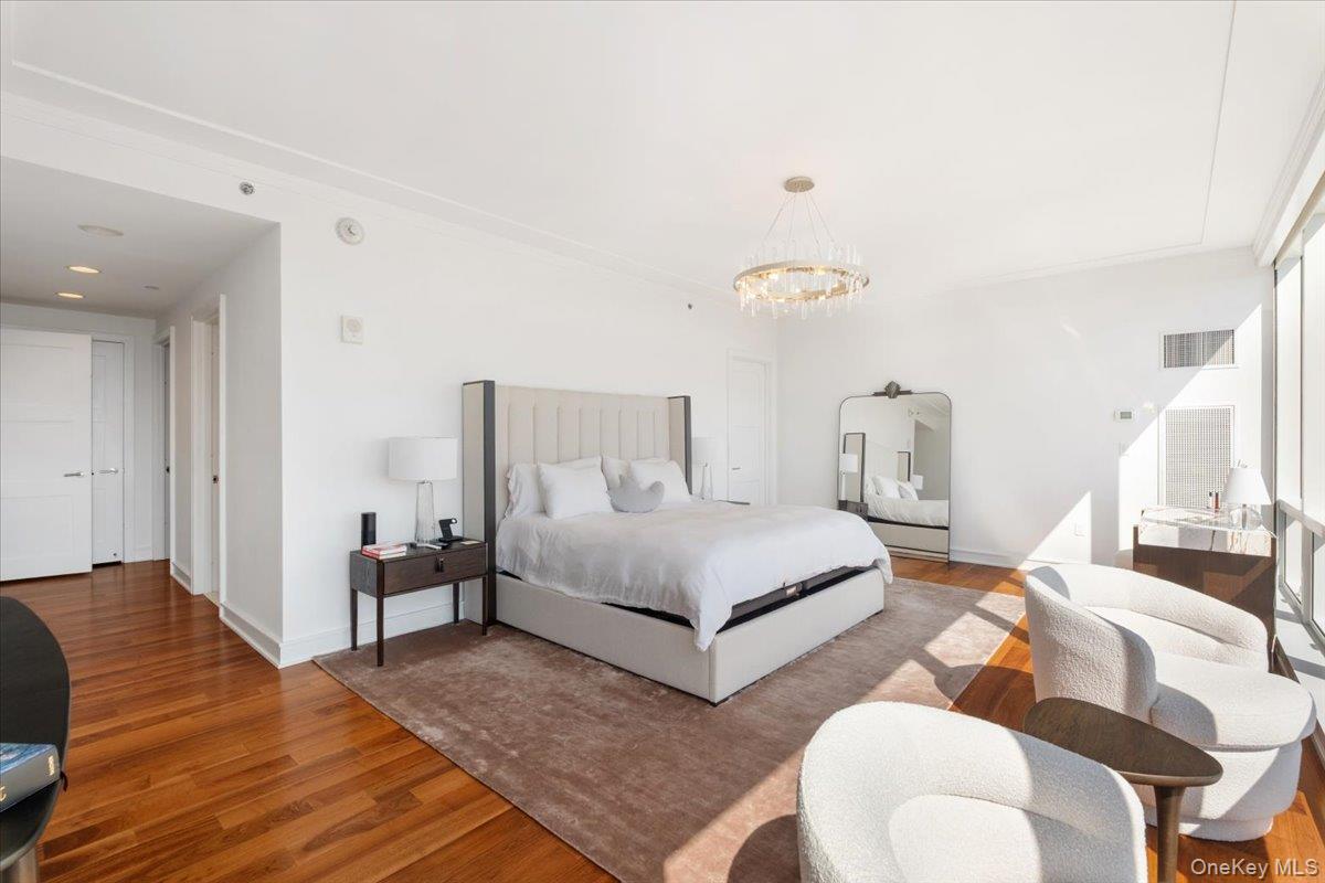 5 Renaissance Square, Unit PH 3E White Plains, NY 10601 - Photo 16 of 26 a bedroom with a bed and wooden floor