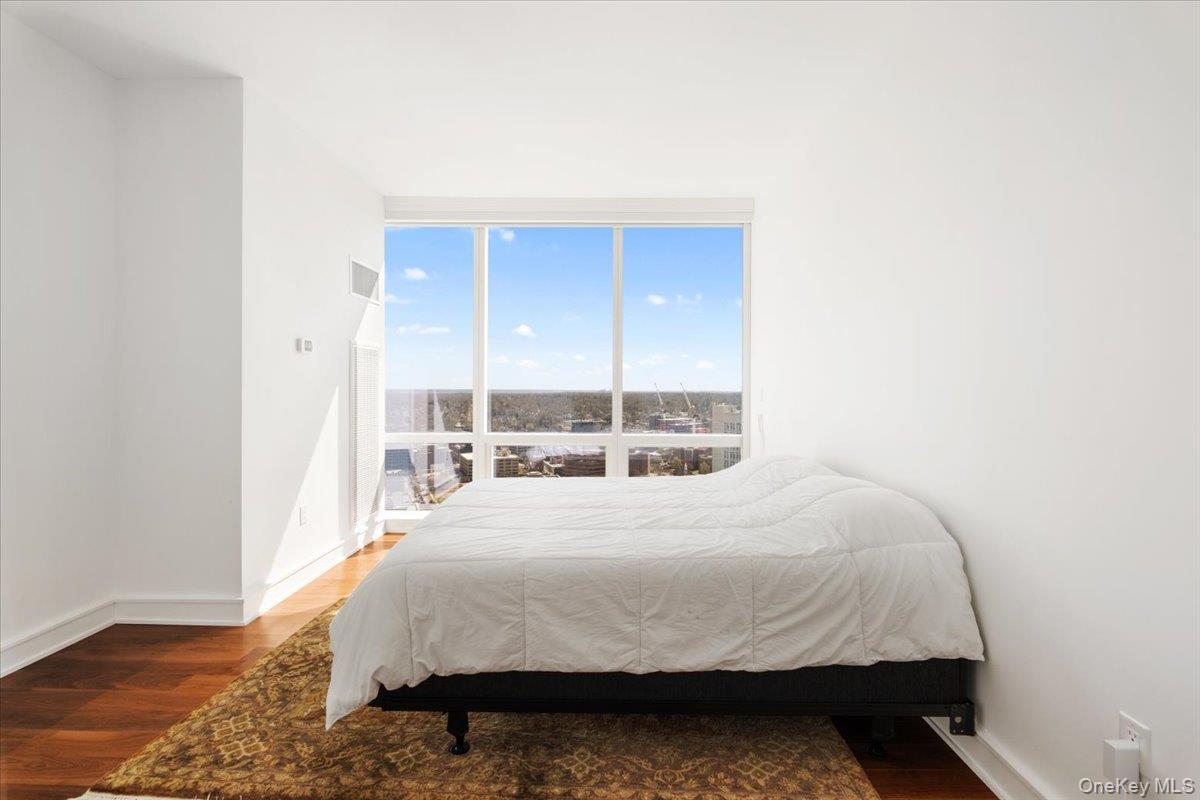 5 Renaissance Square, Unit PH 3E White Plains, NY 10601 - Photo 21 of 26 a bed sitting in a bedroom next to a window