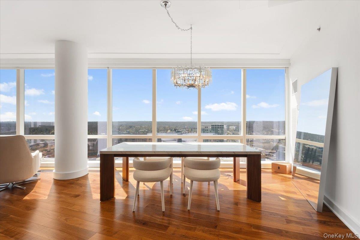 5 Renaissance Square, Unit PH 3E White Plains, NY 10601 - Photo 7 of 26 a room with wooden floor table and chairs