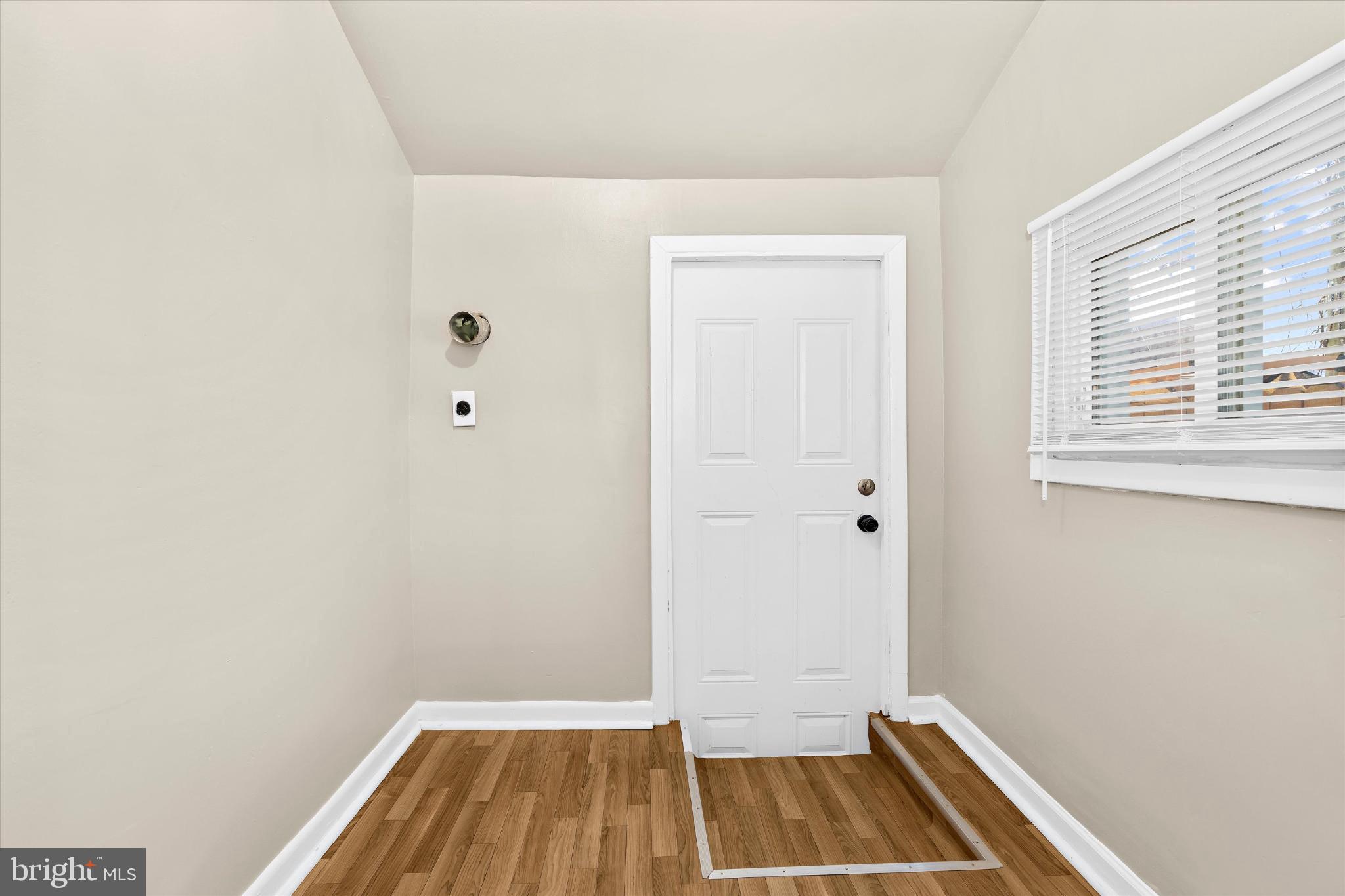 406 Cambria Street Baltimore, MD 21225 - Photo 12 of 26 a view of a room with wooden floor and a window