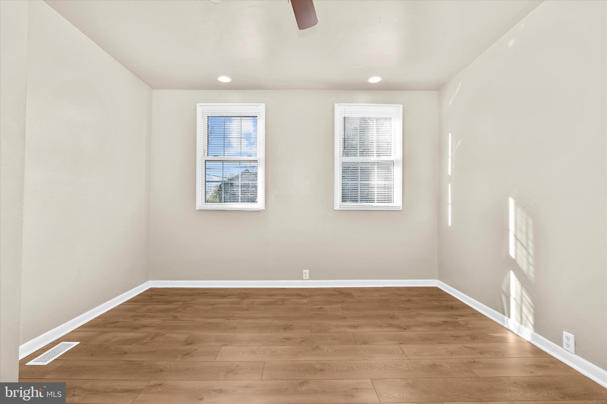 406 Cambria Street Baltimore, MD 21225 - Photo 15 of 26 an empty room with wooden floor and windows