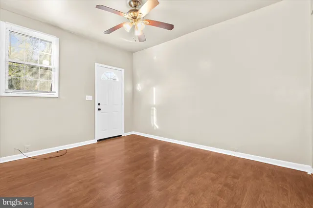an empty room with a window and a fan