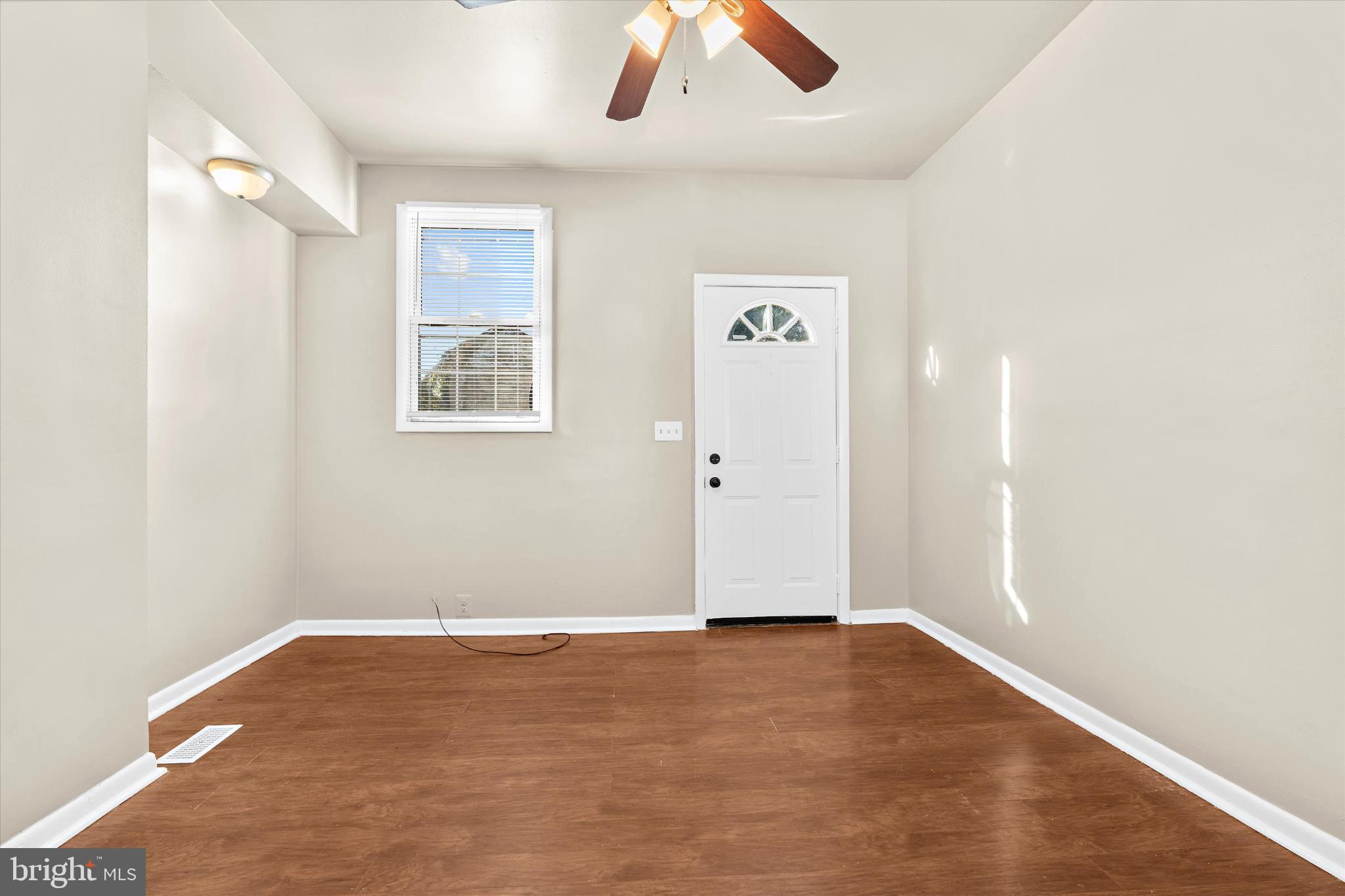 406 Cambria Street Baltimore, MD 21225 - Photo 6 of 26 an empty room with wooden floor and windows