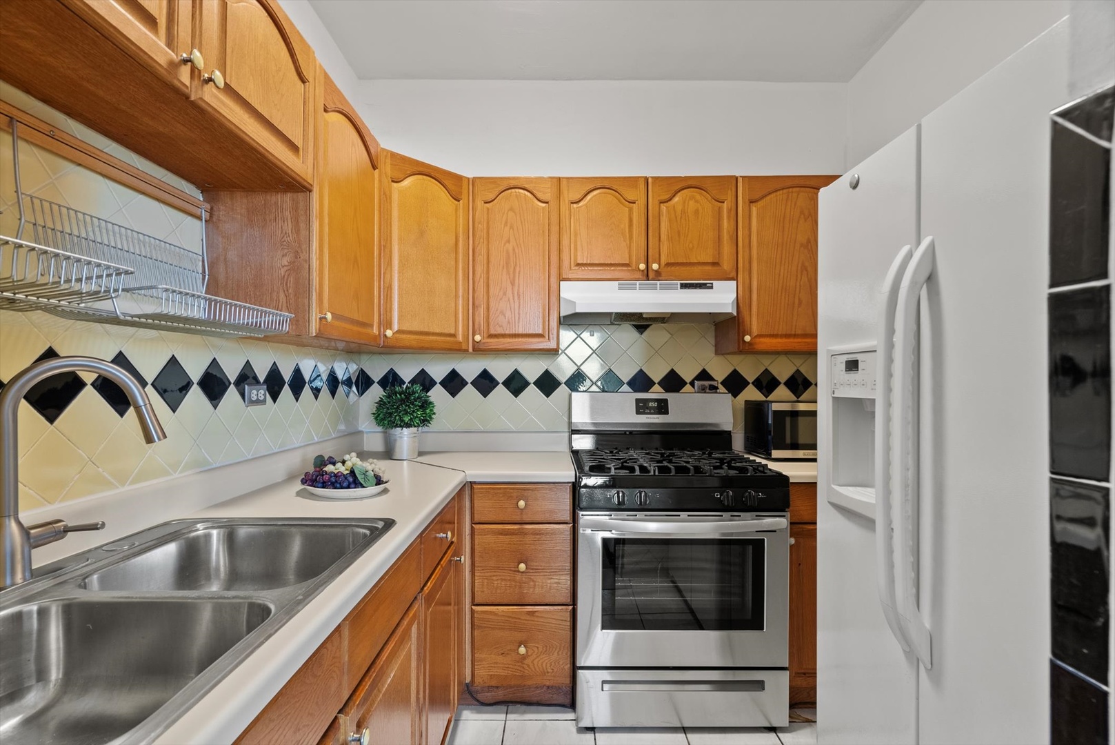 6101 North Sheridan Road, Unit 14C Chicago, IL 60660 - Photo 12 of 20 a kitchen with granite countertop a sink stainless steel appliances and cabinets