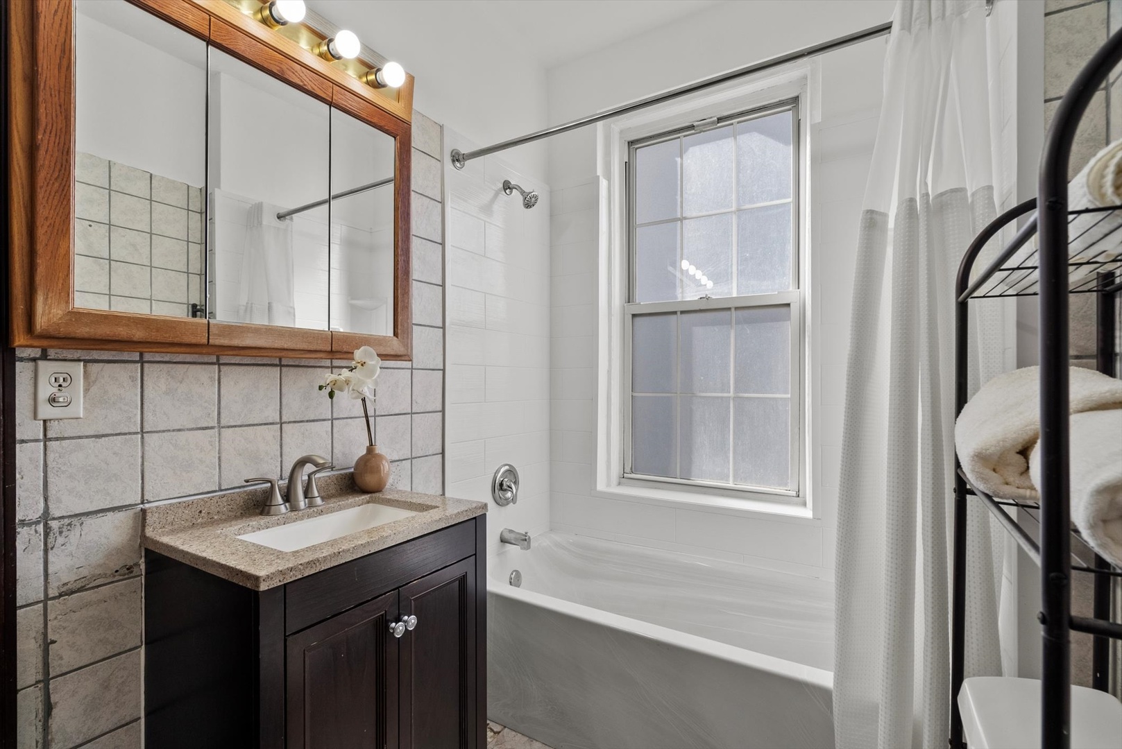 6101 North Sheridan Road, Unit 14C Chicago, IL 60660 - Photo 16 of 20 a bathroom with a granite countertop sink a mirror and shower
