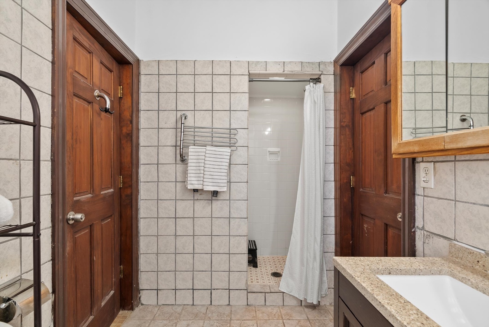 6101 North Sheridan Road, Unit 14C Chicago, IL 60660 - Photo 17 of 20 a bathroom with a granite countertop shower a mirror and a sink