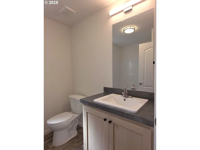 a bathroom with a sink a toilet and mirror