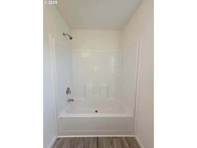 a bathroom with a tub shower and a sink
