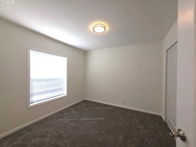 an empty room with windows and closet