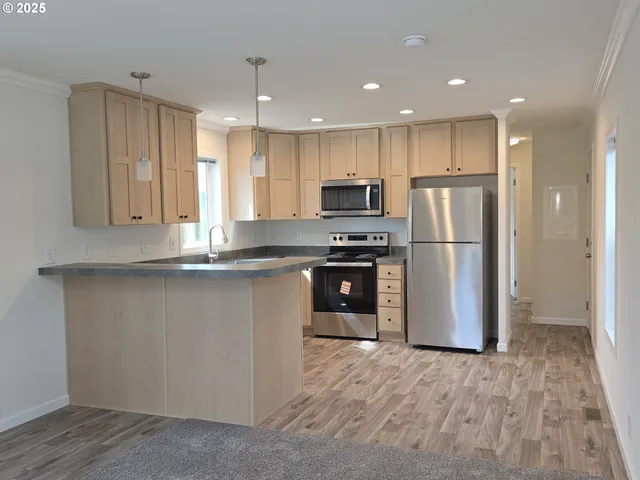 a kitchen with kitchen island a refrigerator sink and cabinets