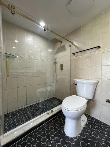 a bathroom with a toilet and a shower