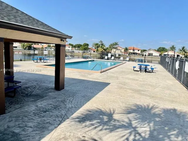a swimming pool with outdoor seating and a yard