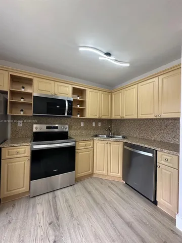 a kitchen with stainless steel appliances granite countertop a stove and cabinets