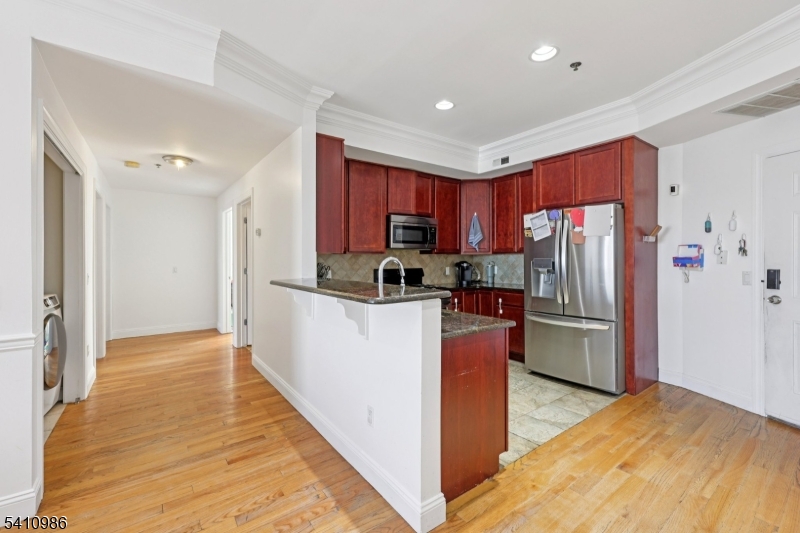 15 Tichenor Street, Unit 407 Newark, NJ 07114 - Photo 13 of 25 a kitchen with refrigerator a microwave and cabinets