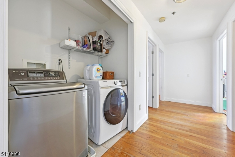 15 Tichenor Street, Unit 407 Newark, NJ 07114 - Photo 14 of 25 a utility room with dryer washer and a view of living room