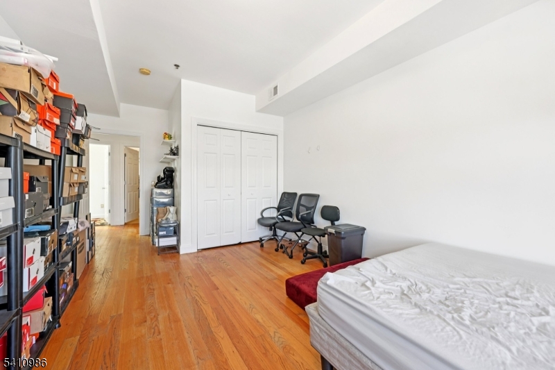 15 Tichenor Street, Unit 407 Newark, NJ 07114 - Photo 18 of 25 a bedroom with furniture and a wooden floor