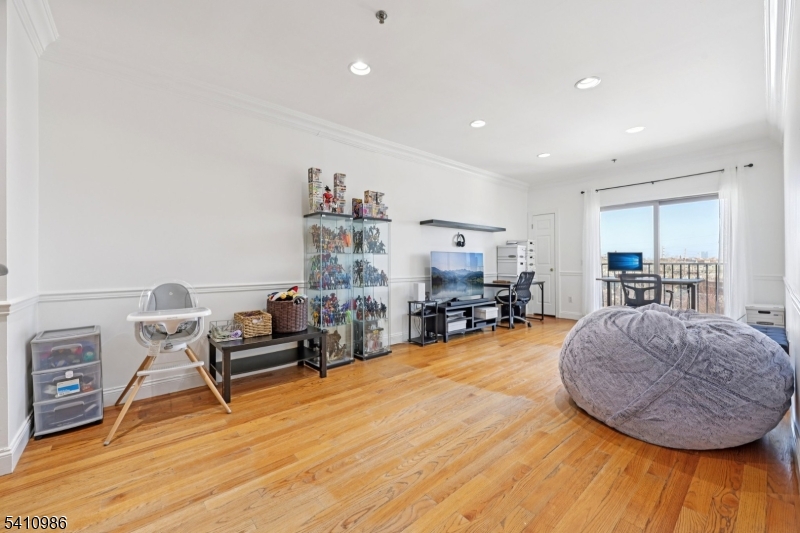 15 Tichenor Street, Unit 407 Newark, NJ 07114 - Photo 3 of 25 a living room with furniture and a wooden floor