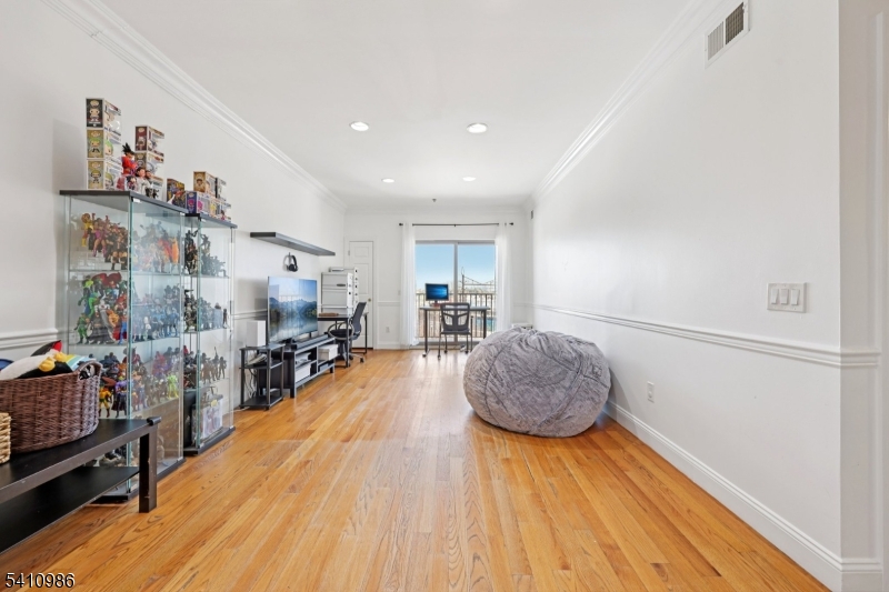 15 Tichenor Street, Unit 407 Newark, NJ 07114 - Photo 5 of 25 a living room with furniture and a wooden floor