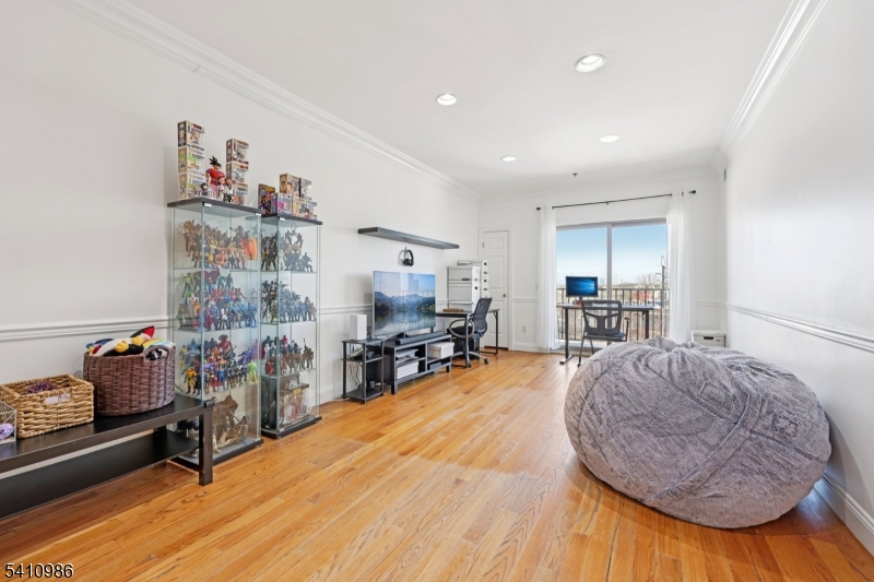 15 Tichenor Street, Unit 407 Newark, NJ 07114 - Photo 8 of 25 a room with furniture and a wooden floor