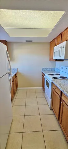 a kitchen with a stove top oven and cabinets