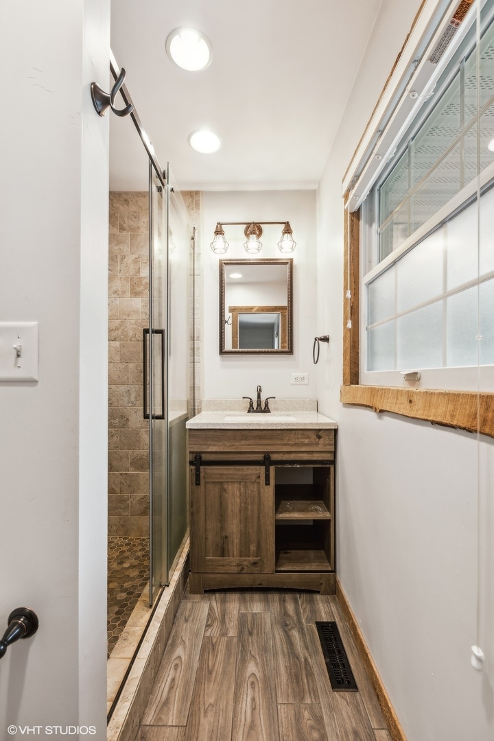 713 Hickory Road Woodstock, IL 60098 - Photo 11 of 13 a bathroom with a sink and a mirror