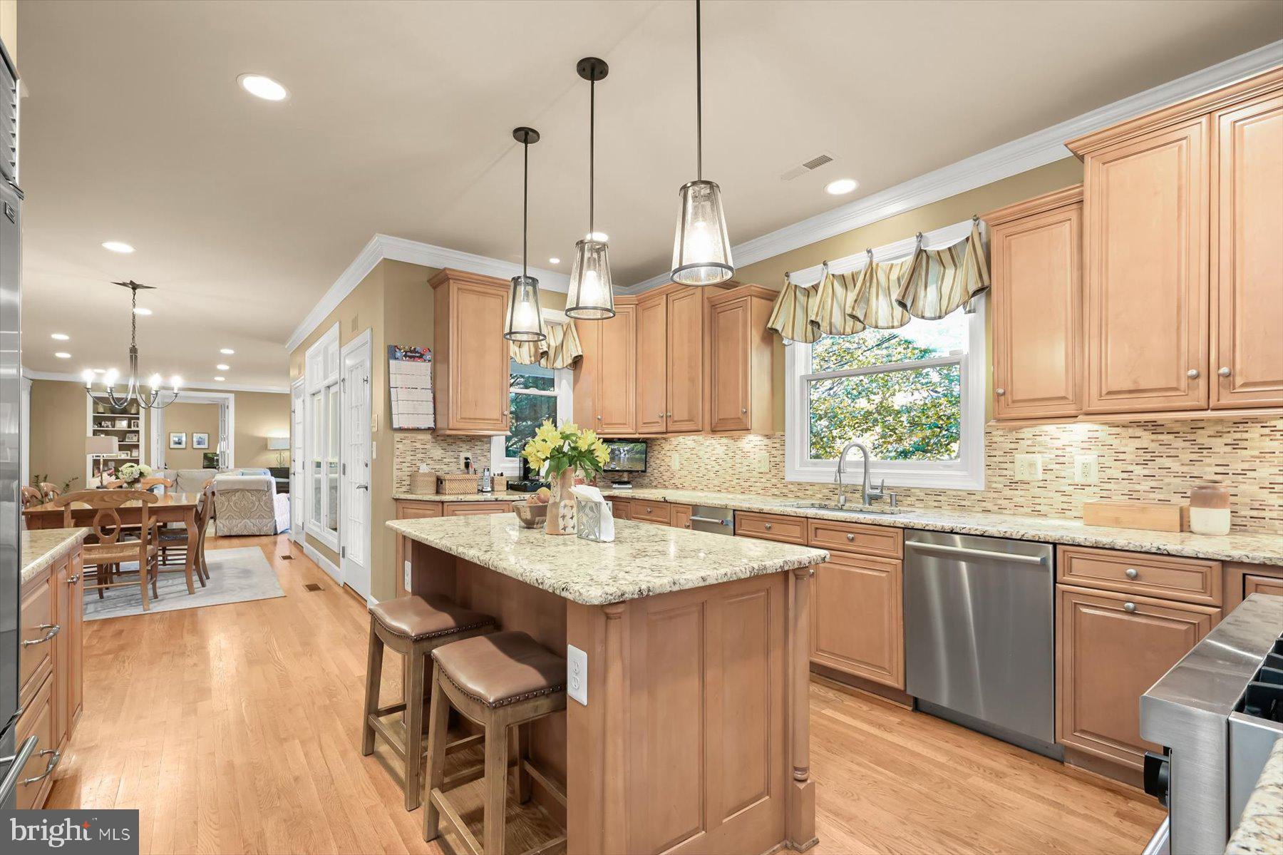 7828 Stable Way Potomac, MD 20854 - Photo 13 of 60 a open kitchen with stainless steel appliances granite countertop a sink a stove a dining table and chairs with wooden floor