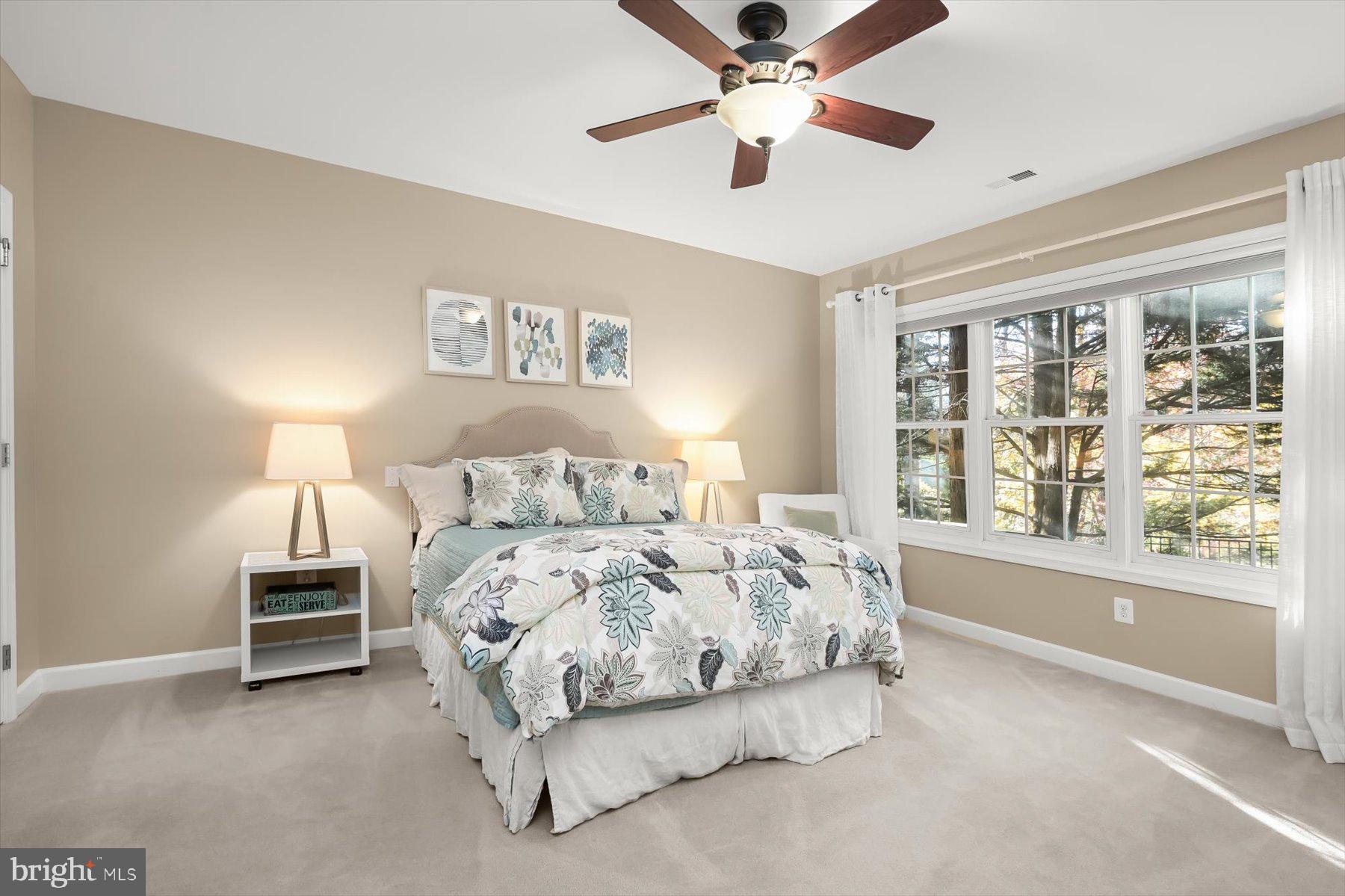 7828 Stable Way Potomac, MD 20854 - Photo 48 of 60 a bedroom with a large bed and a chandelier fan