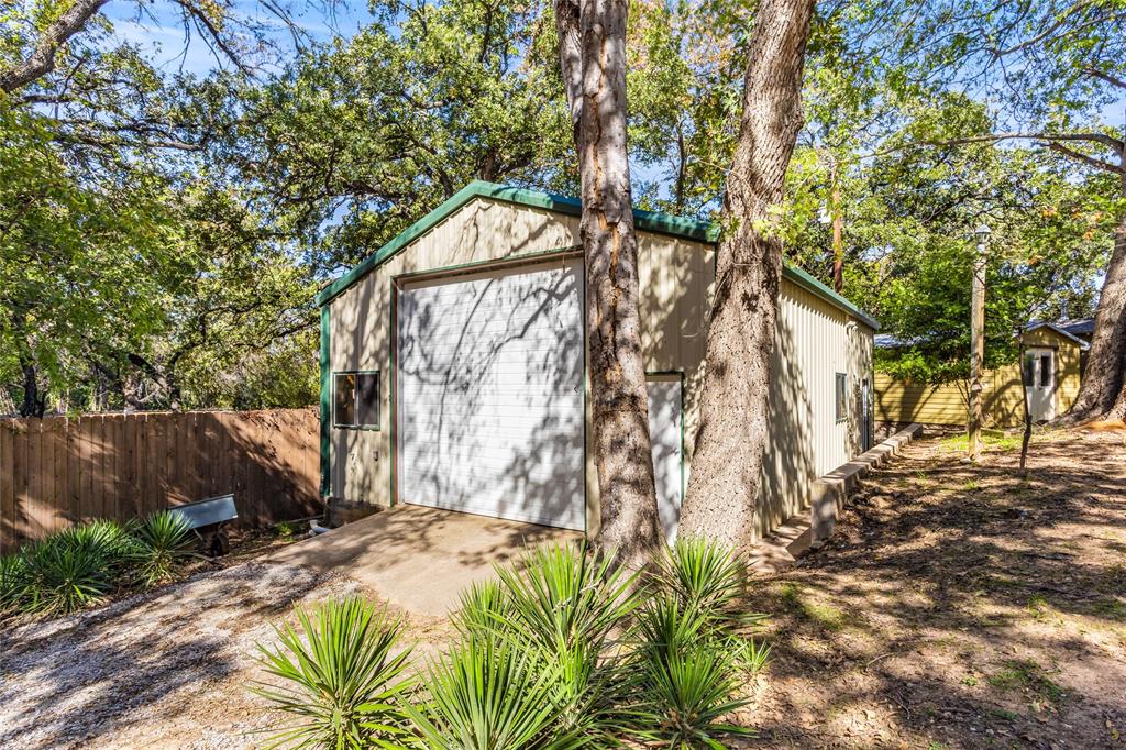 916 Kimbrough Road Azle, TX 76020 - Photo 34 of 40 a backyard of a house with large trees and wooden fence