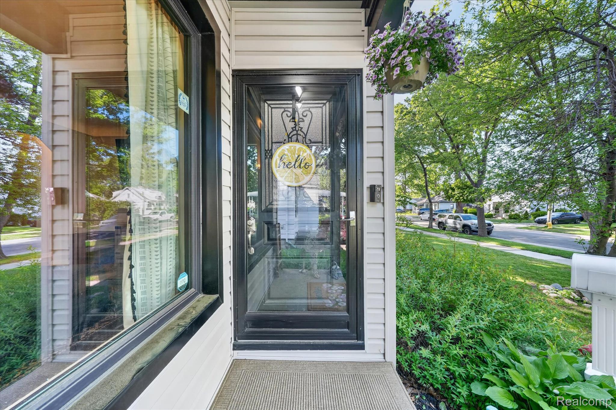 22729 Cleveland Street Dearborn, MI 48124 - Photo 3 of 32 Inviting front entry featuring a black storm door with decorative ironwork, a full-length sidelight, and a covered porch