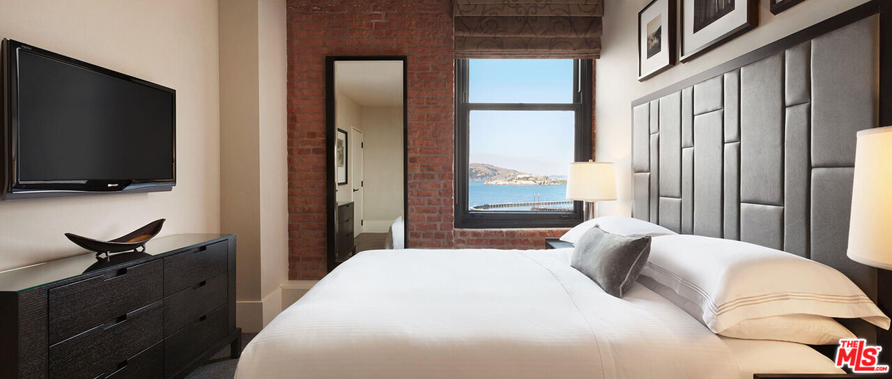 900 North Point Street, Unit 619 San Francisco, CA 94109 - Photo 4 of 12 a bedroom with a bed and a flat tv screen on dresser